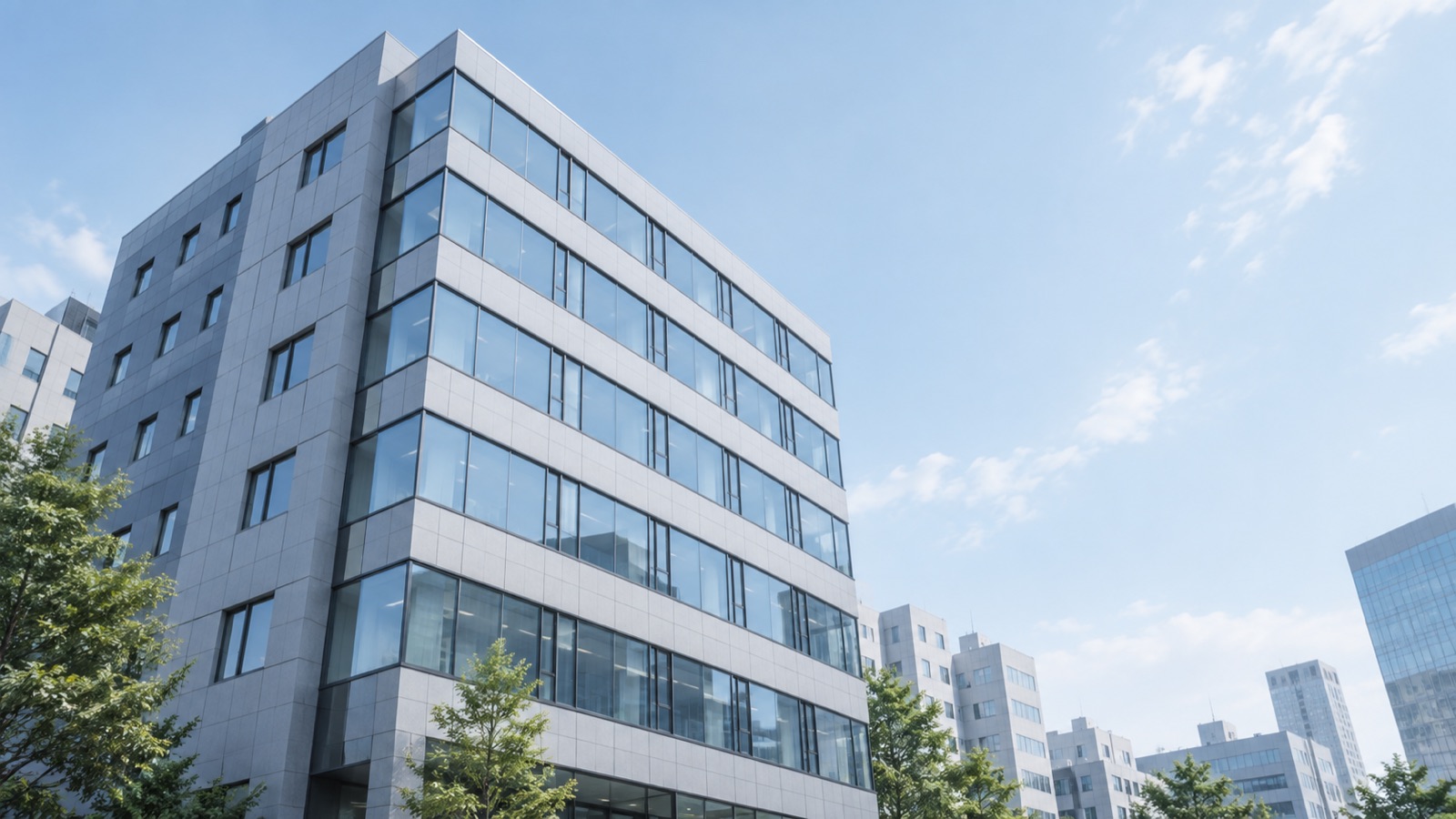 午前の光を受ける中小規模オフィスビルの端正な外観