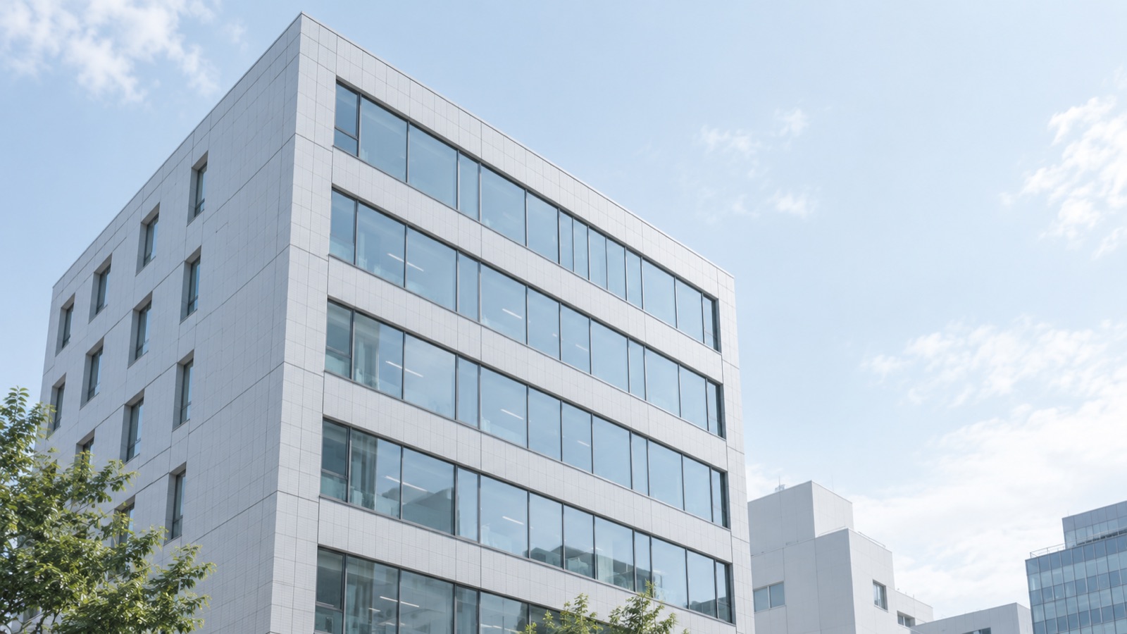 午前の光を受ける中小規模オフィスビルの端正な外観